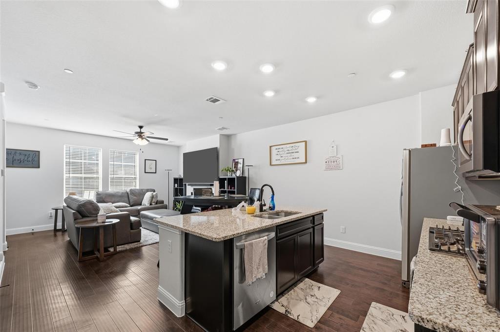 3544 Thistlewood Drive Plano, TX 75074 - Photo 24 of 24 a kitchen with stainless steel appliances granite countertop a stove top oven a sink dishwasher a dining table and chairs with wooden floor