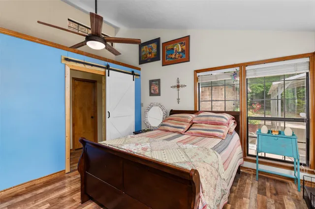a bedroom with a bed and a dresser next to a window