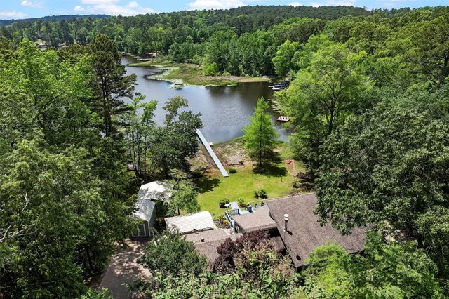 an aerial view of a house with a yard and lake view