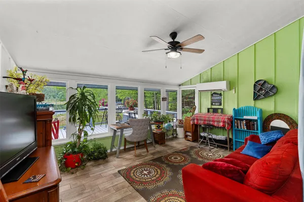 a living room with furniture a floor to ceiling window and a flat screen tv