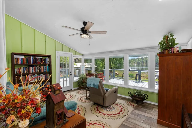 a living room with furniture a bookshelf and a window