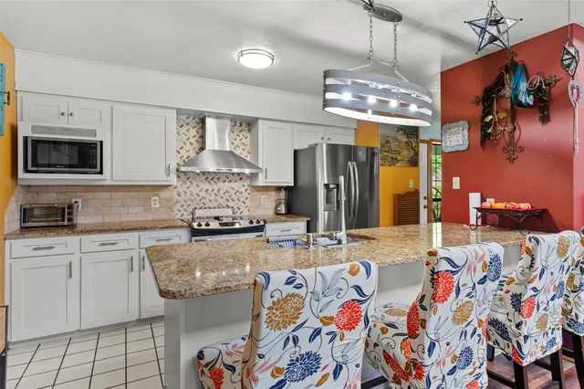 a kitchen with stainless steel appliances granite countertop a sink and a refrigerator