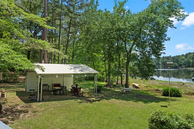 a view of a swimming pool with a table and chairs under an umbrella
