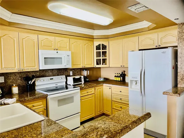 a kitchen with a sink appliances and cabinets