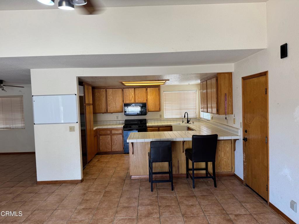 19163 Paradise Mountain Road Valley Center, CA 92082 - Photo 5 of 74 a kitchen with a sink and chairs