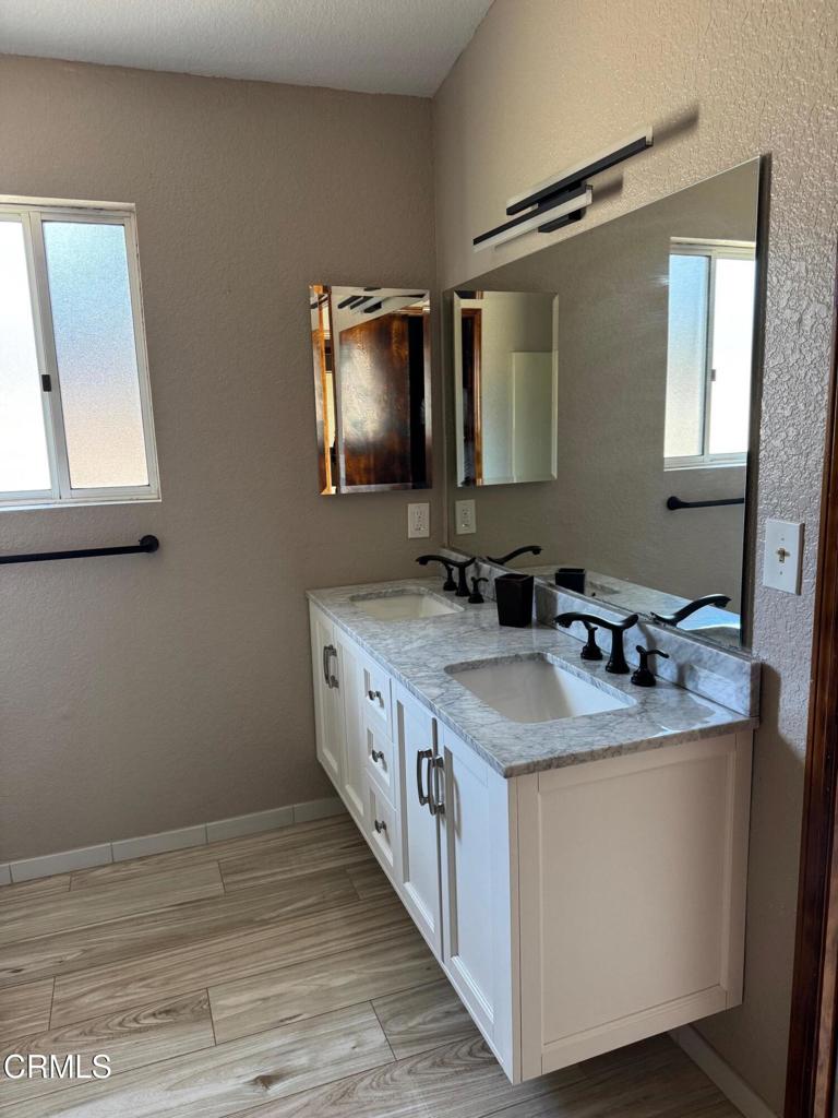 19163 Paradise Mountain Road Valley Center, CA 92082 - Photo 9 of 74 a en suite bathroom with a granite countertop sink and a mirror