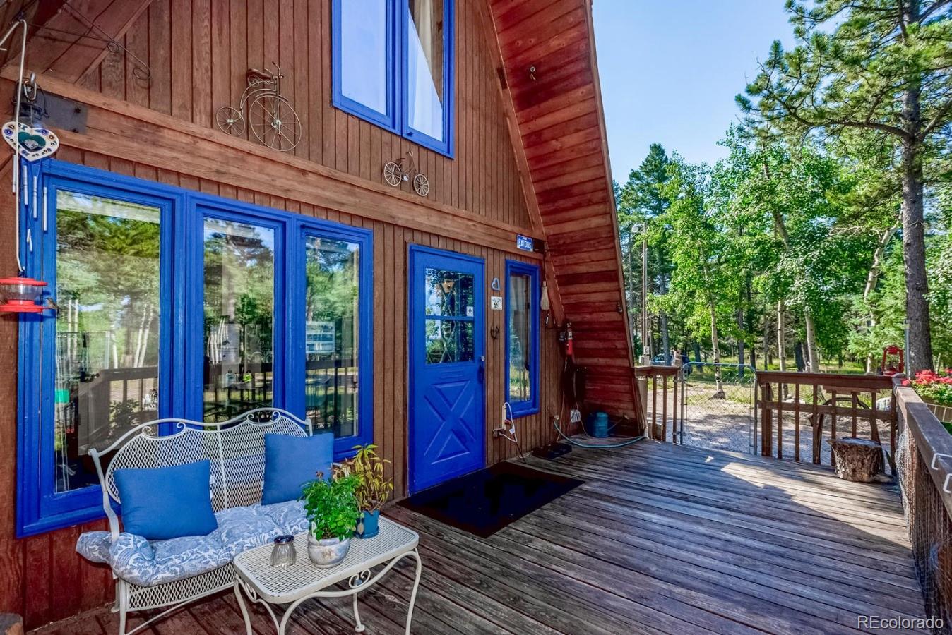 12802 Upper Ridge Road Conifer, CO 80433 - Photo 18 of 27 a view of a house with chairs and wooden floor