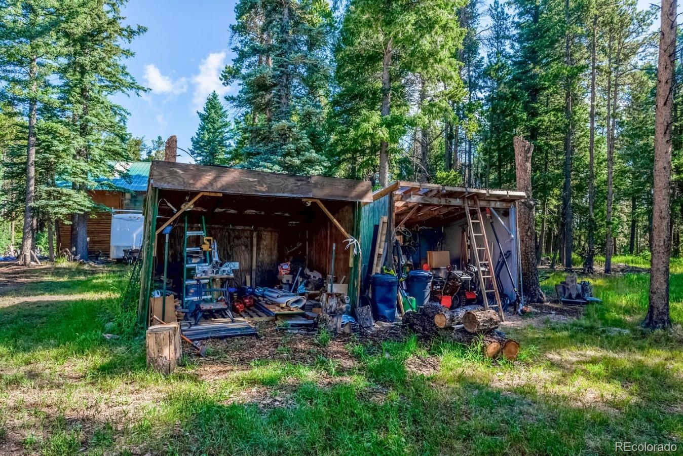 12802 Upper Ridge Road Conifer, CO 80433 - Photo 22 of 27 a view of a chairs and table in a yard
