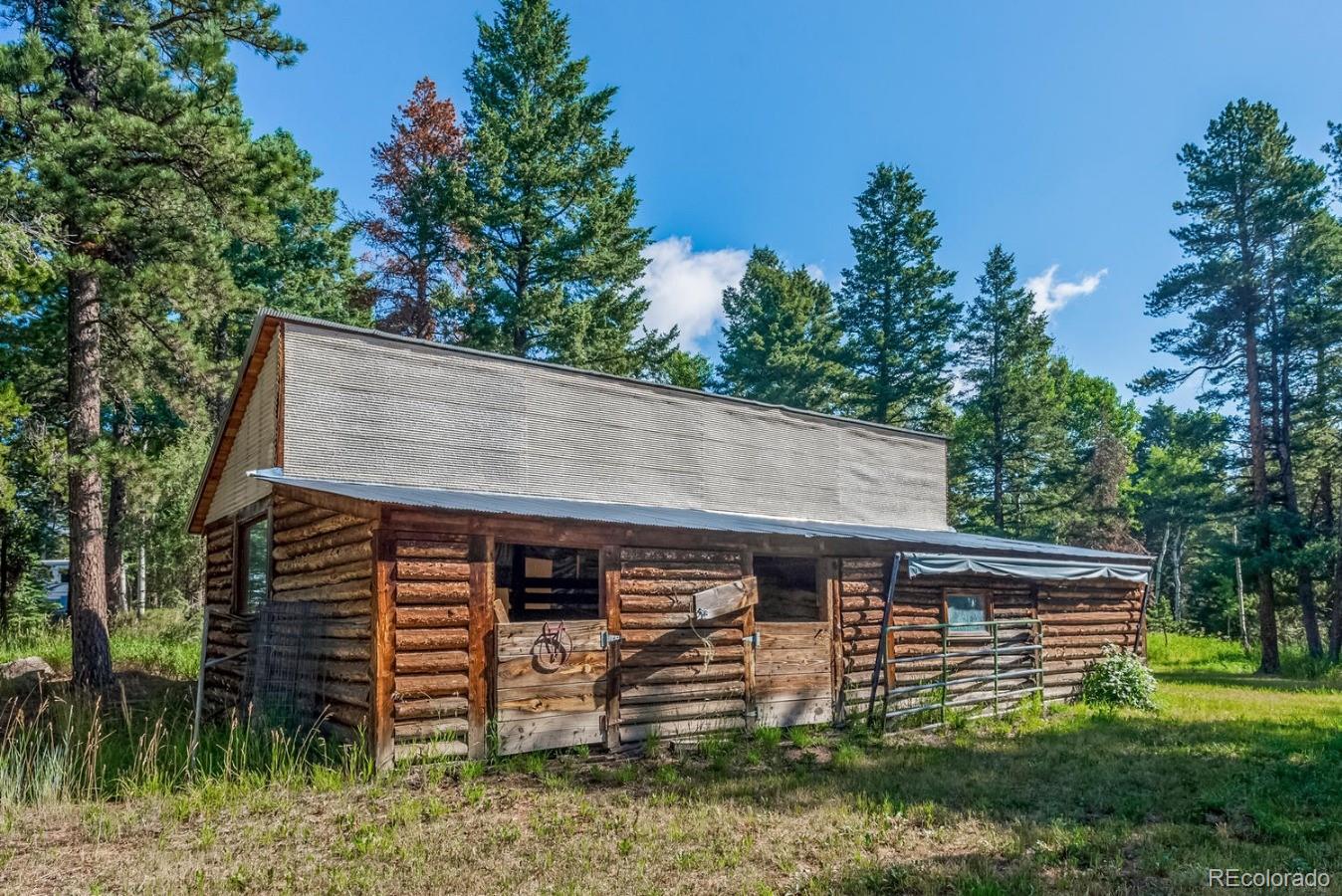 12802 Upper Ridge Road Conifer, CO 80433 - Photo 23 of 27 front view of a house with a yard