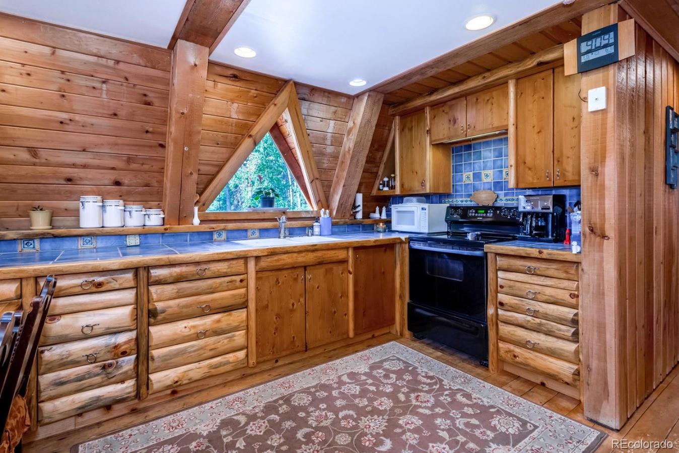 12802 Upper Ridge Road Conifer, CO 80433 - Photo 4 of 27 a kitchen with a sink cabinets and window
