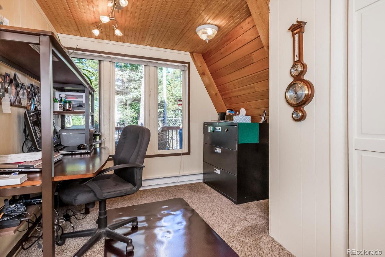 12802 Upper Ridge Road Conifer, CO 80433 - Photo 10 of 27 a view of a workspace with furniture and a window