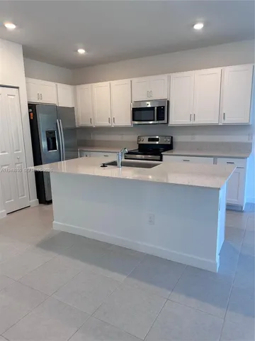 a kitchen with stainless steel appliances a refrigerator sink and microwave