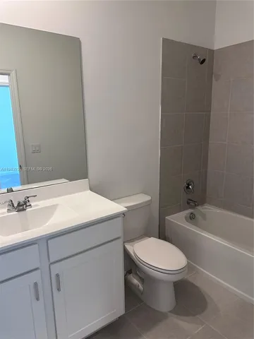 a bathroom with a toilet a sink a mirror and bathtub