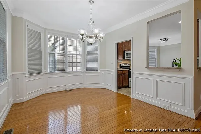 a view of a kitchen with wooden floor and stainless steel appliances