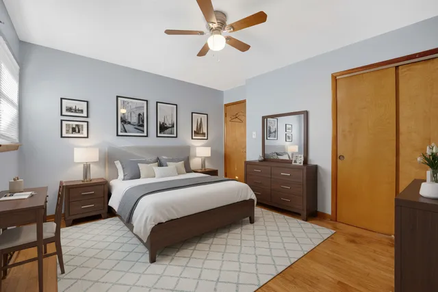 a bedroom with a bed painting on wall and a large window