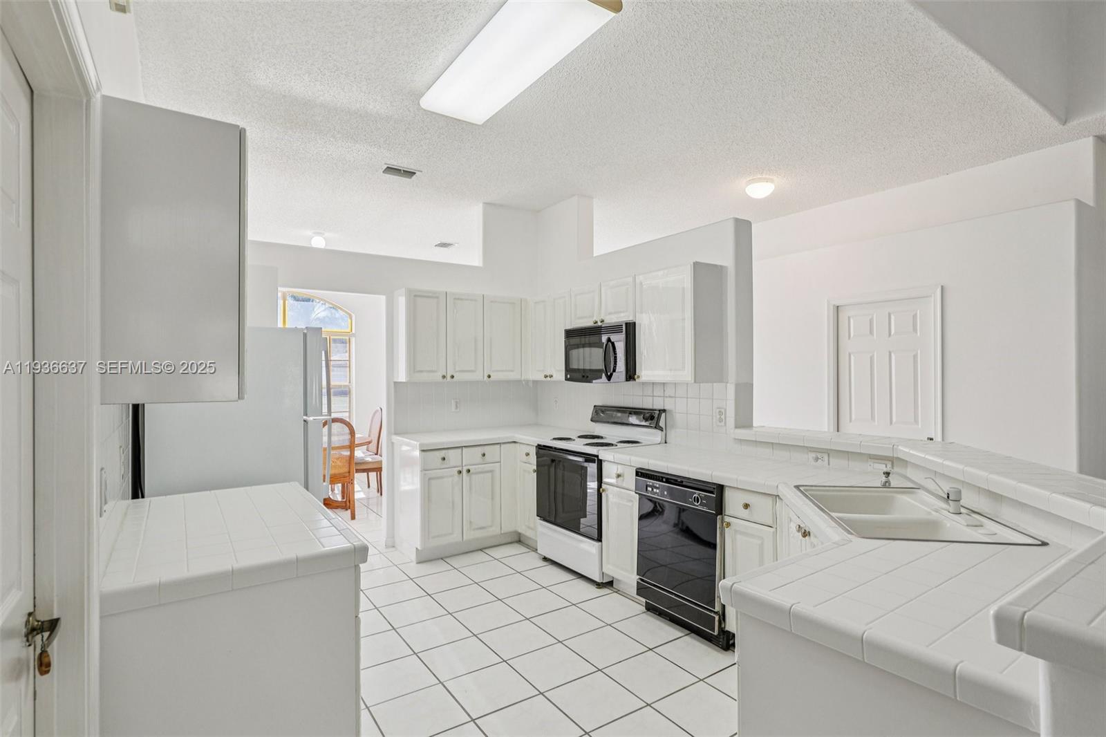 17811 Southwest 4th Court Pembroke Pines, FL 33029 - Photo 20 of 74 a kitchen with stainless steel appliances a stove refrigerator sink and microwave