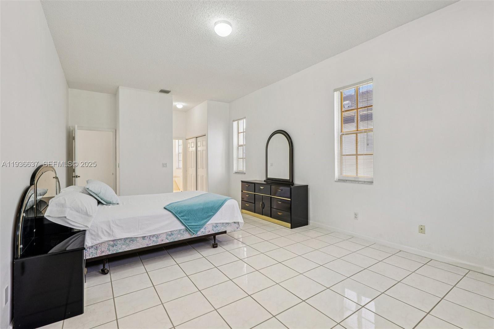 17811 Southwest 4th Court Pembroke Pines, FL 33029 - Photo 33 of 74 a bedroom with a bed and a potted plant on dresser