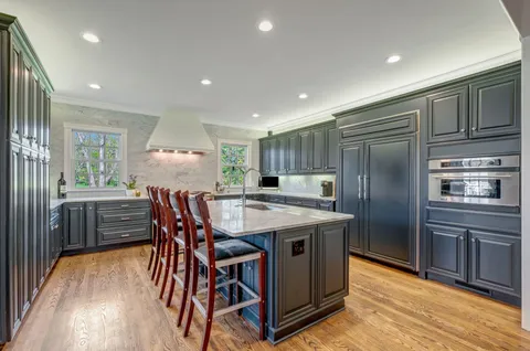 a kitchen with stainless steel appliances granite countertop a table chairs and a refrigerator
