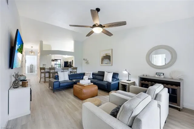 a living room with furniture kitchen view and a mirror