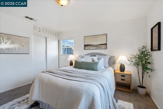 a bedroom with a bed and a potted plant