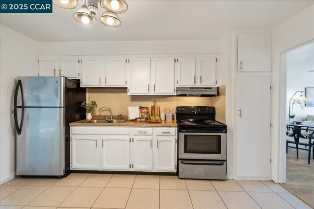 a kitchen with stainless steel appliances granite countertop a refrigerator a stove a sink and dishwasher