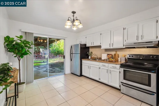 a kitchen with granite countertop a refrigerator a stove a oven a counter space and cabinets