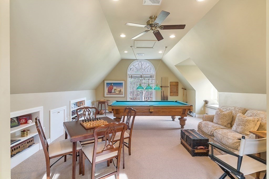 853 Strawberry Hill Road Concord, MA 01742 - Photo 32 of 41 a living room with furniture a clock and a chandelier