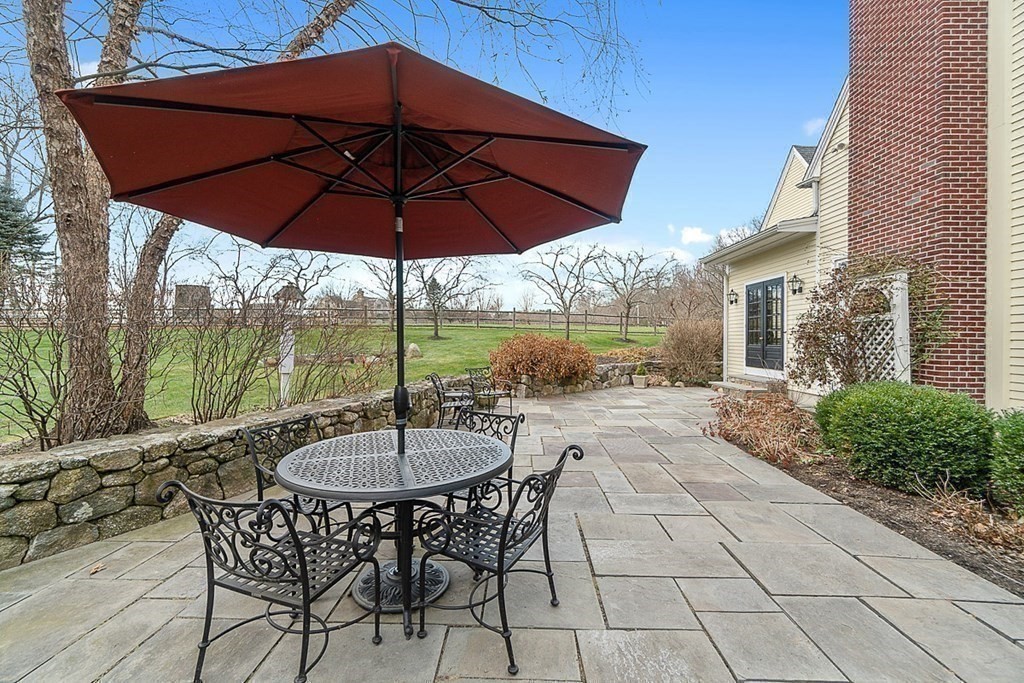 853 Strawberry Hill Road Concord, MA 01742 - Photo 37 of 41 a view of a patio with a table and chairs under an umbrella