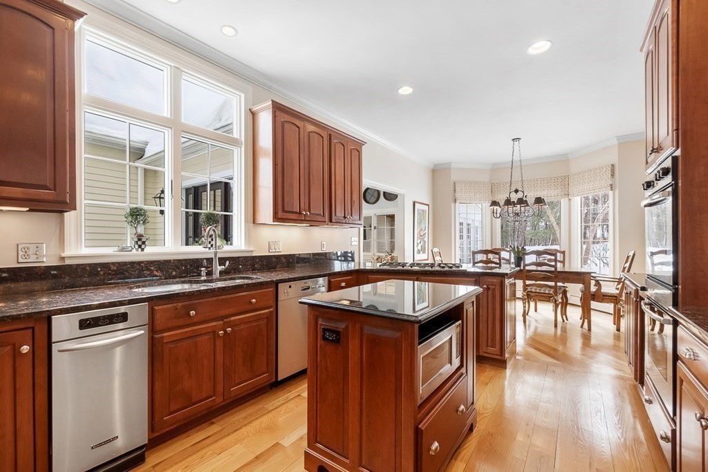 853 Strawberry Hill Road Concord, MA 01742 - Photo 10 of 41 a kitchen with stainless steel appliances granite countertop wooden cabinets a sink a stove a dining table and chairs