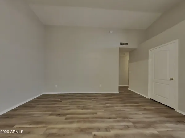 a view of empty room with wooden floor