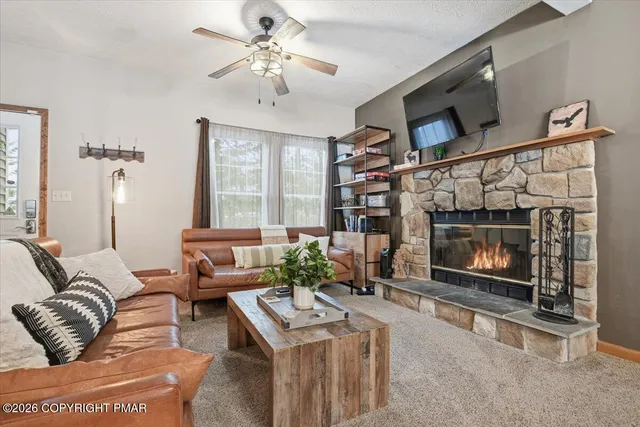 a living room with furniture a fireplace and a flat screen tv
