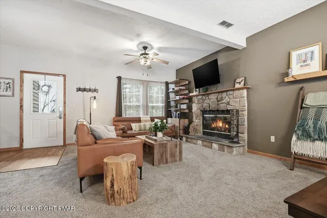 a living room with furniture a flat screen tv and a fireplace