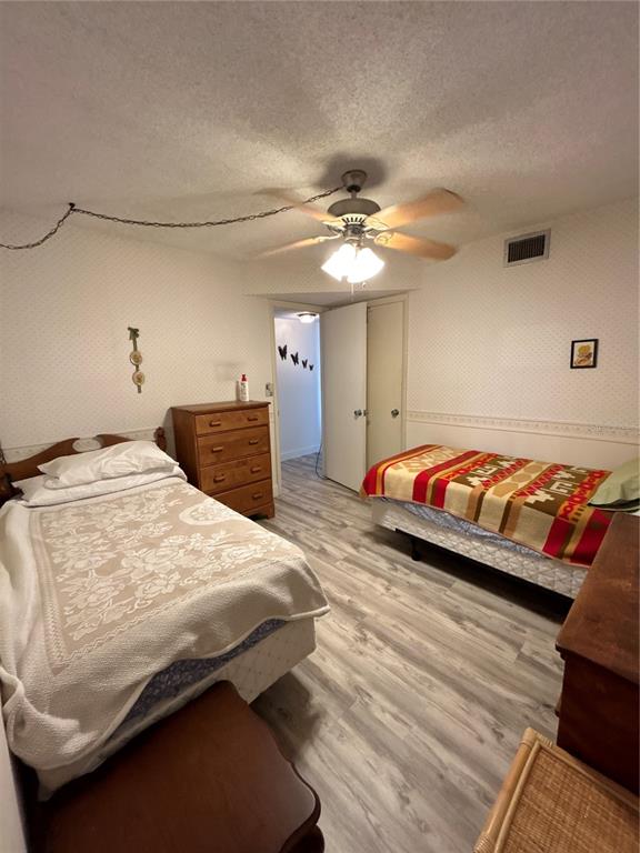 4775 Cove Circle, Unit 1202 Madeira Beach, FL 33708 - Photo 15 of 32 a bedroom with a bed and a chandelier