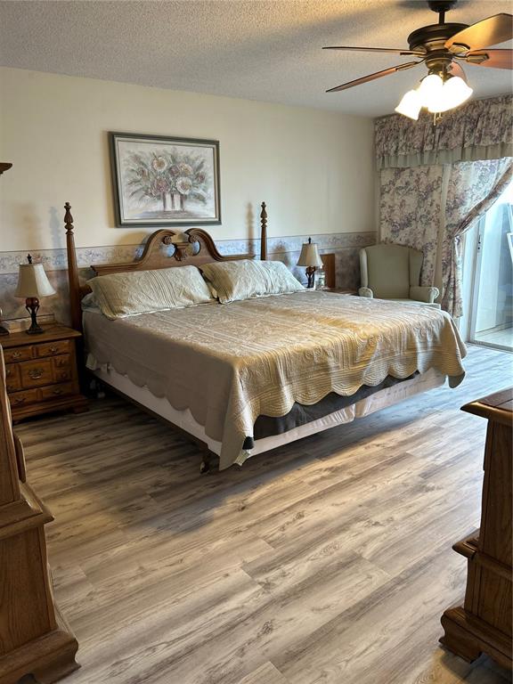 4775 Cove Circle, Unit 1202 Madeira Beach, FL 33708 - Photo 16 of 32 a spacious bedroom with a bed and a chandelier