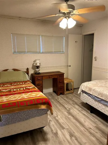 a spacious bedroom with a bed and a ceiling fan