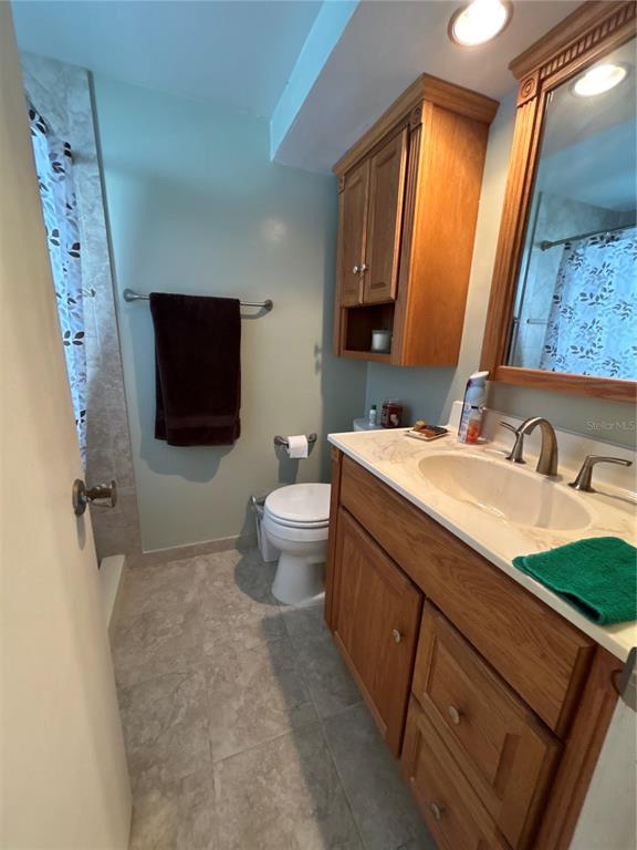 4775 Cove Circle, Unit 1202 Madeira Beach, FL 33708 - Photo 19 of 32 a bathroom with a sink a toilet and mirror