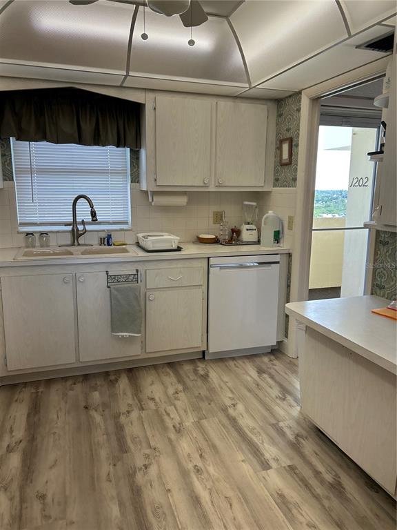 4775 Cove Circle, Unit 1202 Madeira Beach, FL 33708 - Photo 24 of 32 a kitchen with stainless steel appliances granite countertop a sink a stove and white cabinets