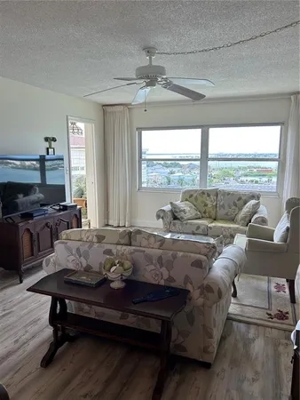 a living room with furniture ceiling fan and a window