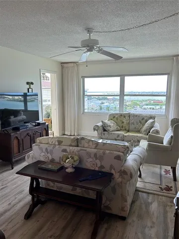 a living room with furniture ceiling fan and a window
