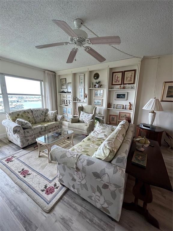 4775 Cove Circle, Unit 1202 Madeira Beach, FL 33708 - Photo 8 of 32 a living room with furniture ceiling fan and a window