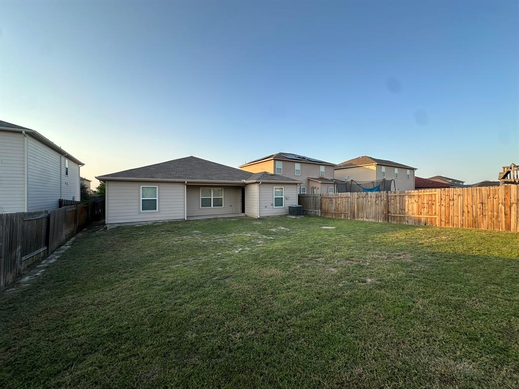 1818 Clegg Street Howe, TX 75459 - Photo 33 of 34 Spacious backyard featuring a manicured lawn, a full wood privacy fence, and a neutral-toned exterior with multiple windows