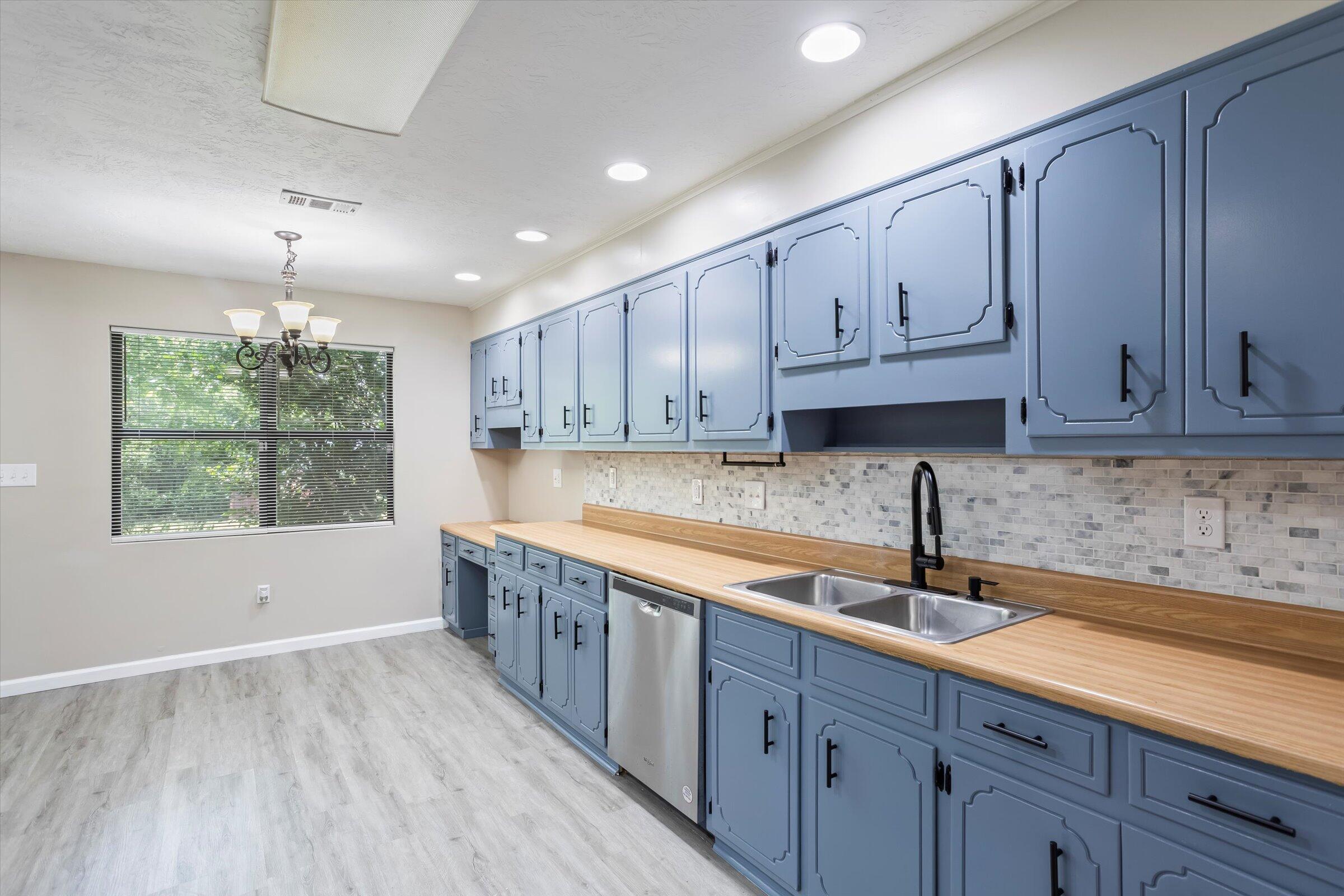 305 Manchester Court Grovetown, GA 30813 - Photo 4 of 13 a kitchen with kitchen island granite countertop a sink window and cabinets