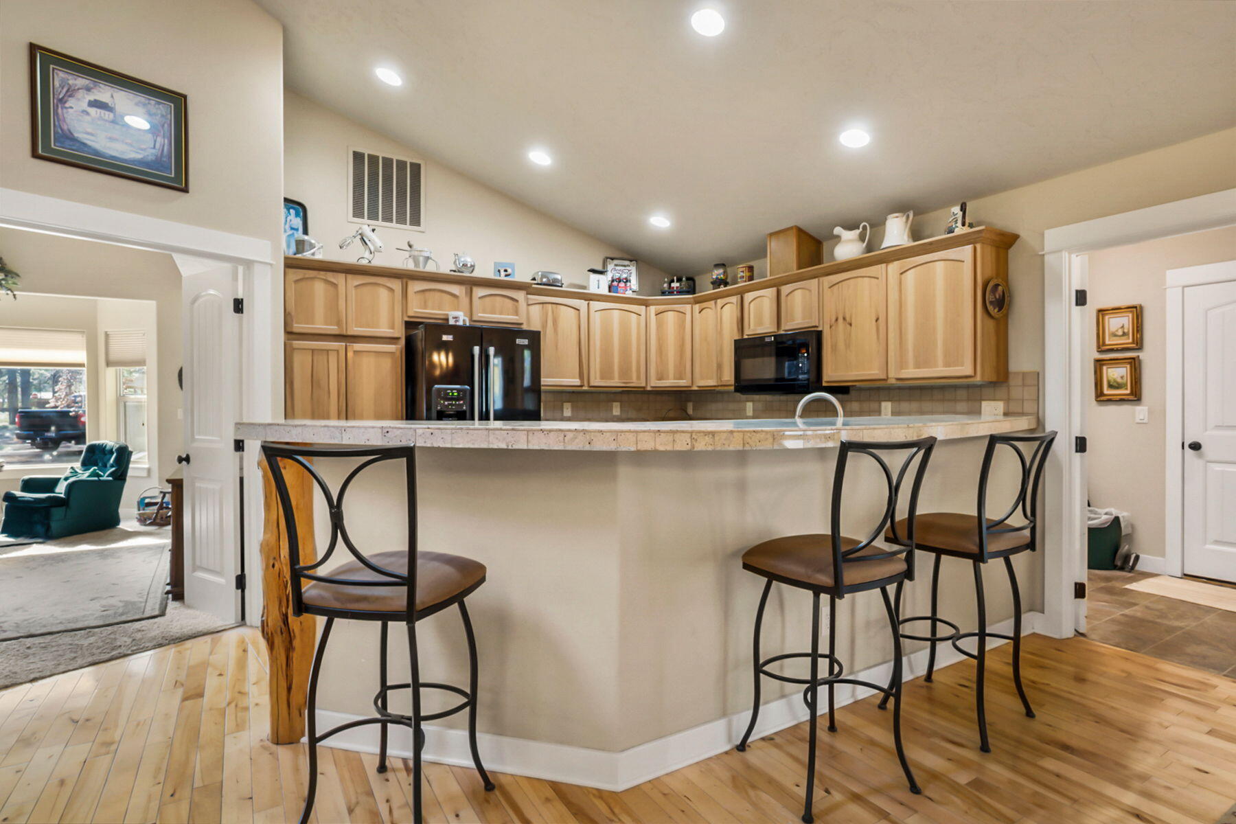 17048 Norwalk Road Bend, OR 97707 - Photo 11 of 36 a kitchen with stainless steel appliances kitchen island granite countertop a dining table chairs and a refrigerator