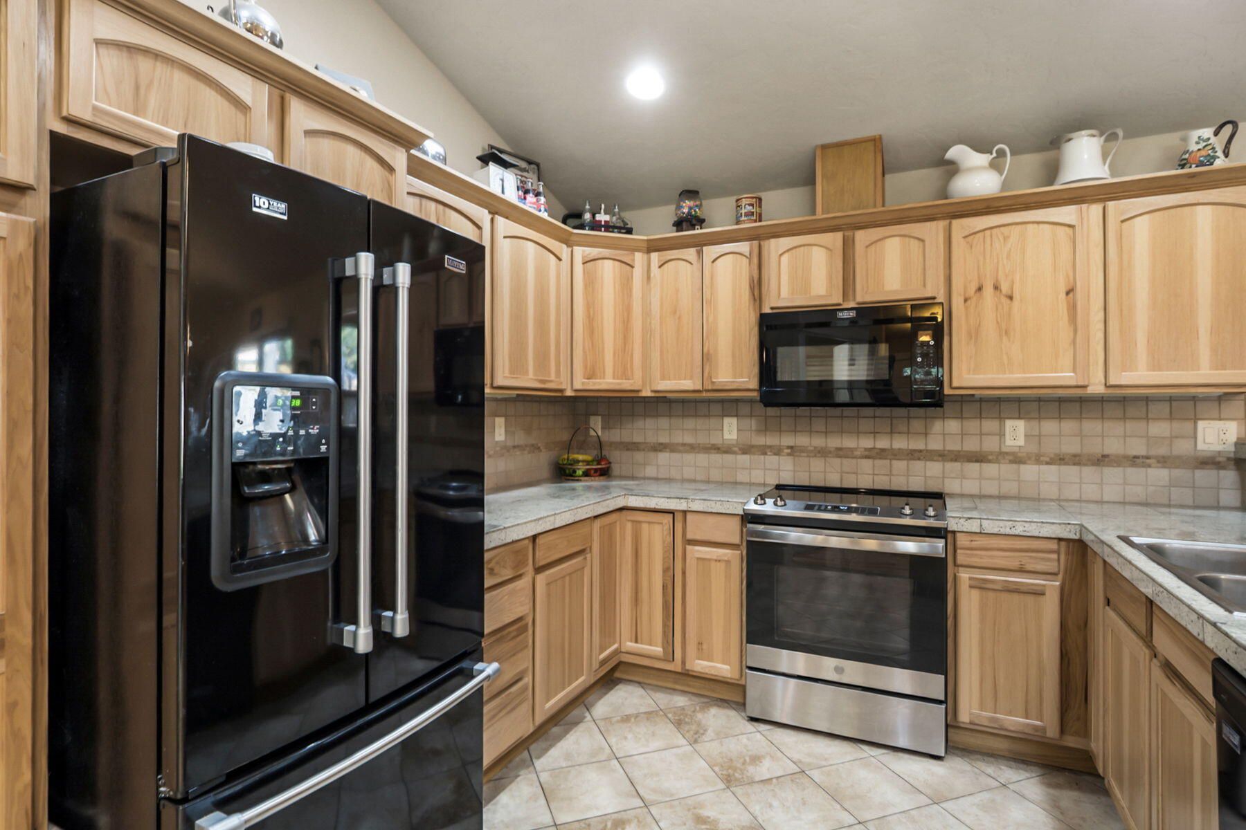 17048 Norwalk Road Bend, OR 97707 - Photo 8 of 36 a kitchen with stainless steel appliances granite countertop a stove a microwave and a refrigerator