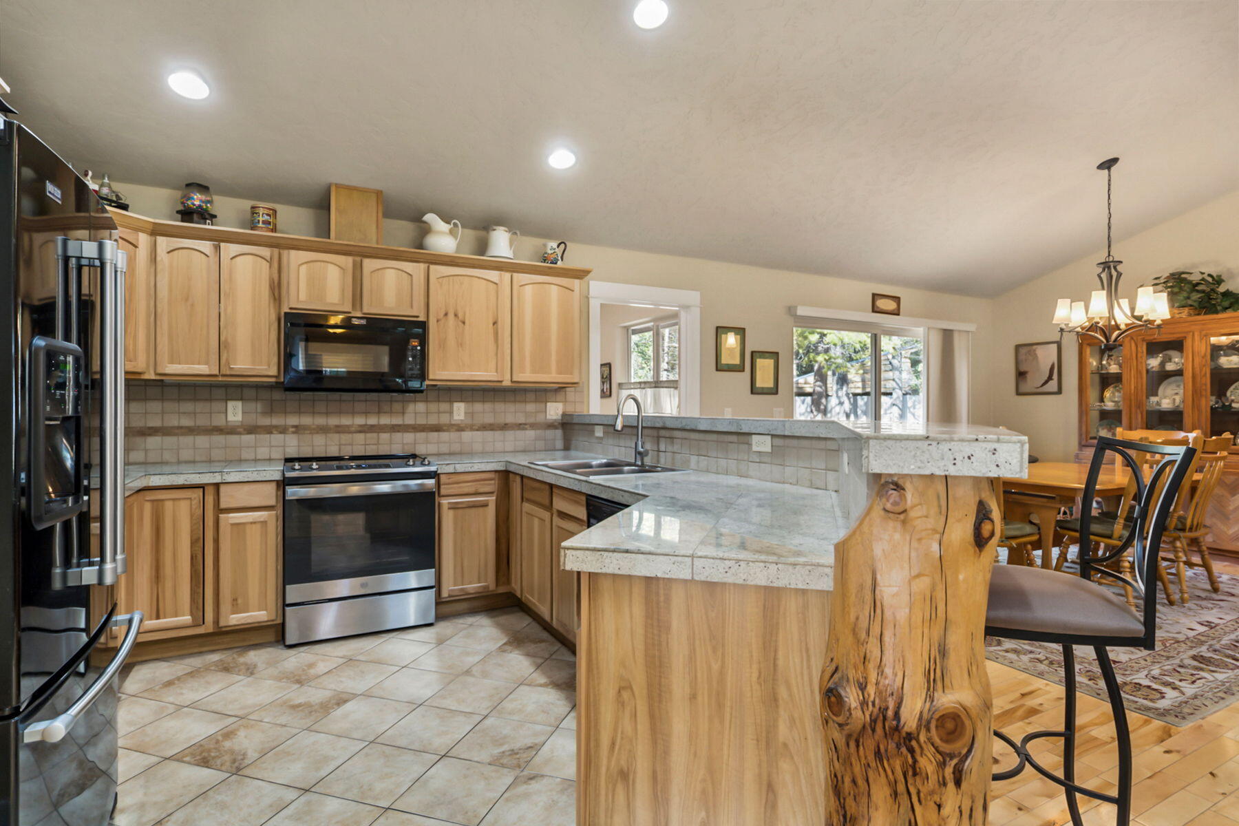 17048 Norwalk Road Bend, OR 97707 - Photo 9 of 36 a kitchen with stainless steel appliances kitchen island granite countertop a stove top oven a sink and cabinets