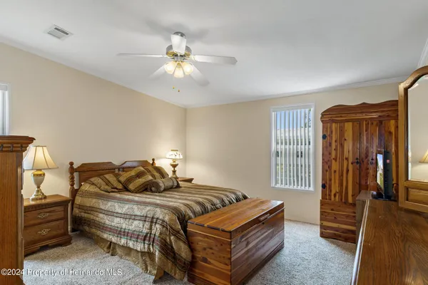 a bedroom with a bed and dresser with mirror