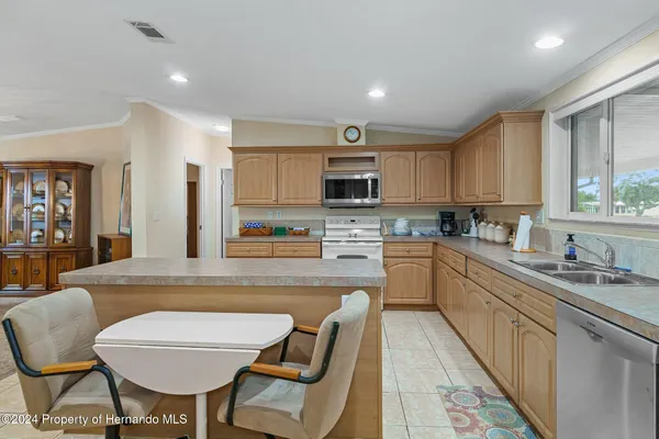 a kitchen with stainless steel appliances granite countertop a sink stove microwave and refrigerator