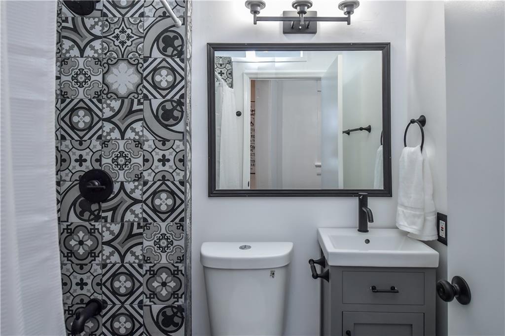 806 Vedado Way Northeast, Unit 1 Atlanta, GA 30308 - Photo 2 of 5 a bathroom with a sink and mirror with toilet