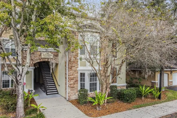 a front view of a house with garage and plants