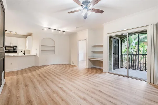 a view of a kitchen with wooden floor and a ceiling fan
